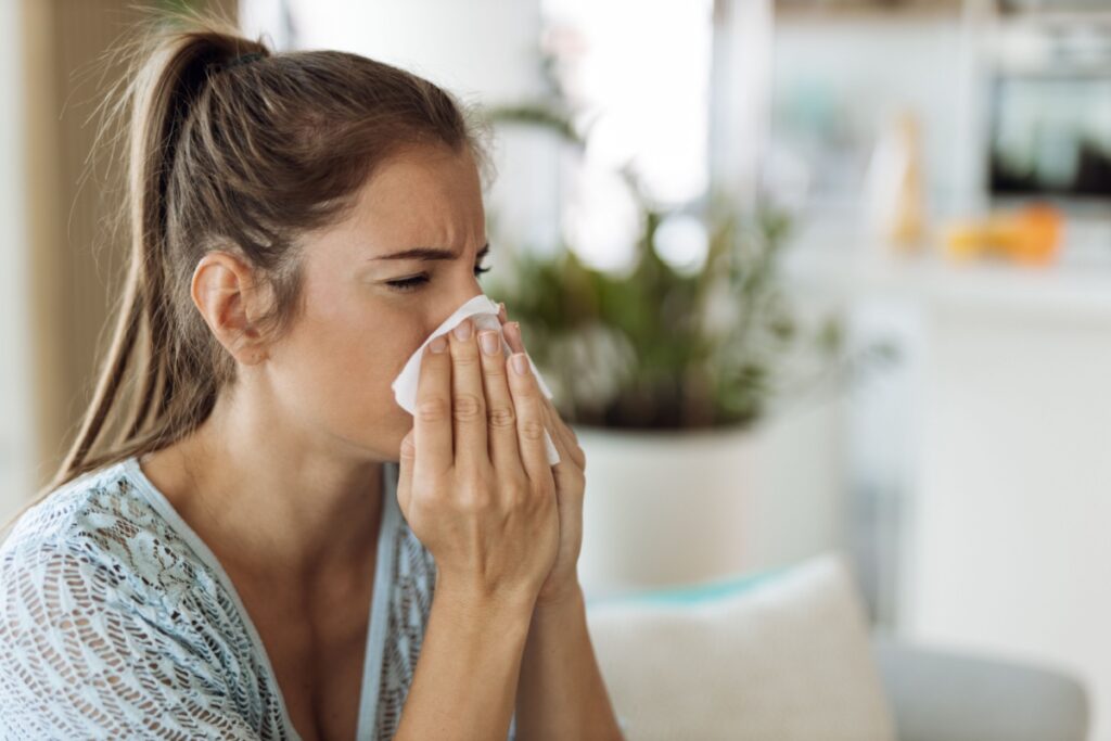 A person blowing their nose into a tissue